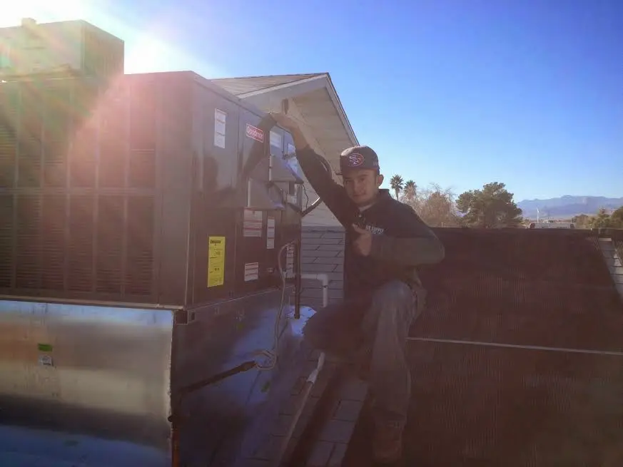 HVAC technician performing HVAC Inspection on a rooftop unit in Springdale